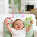 baby is holding teether and laughing