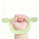 baby holding handle of teether